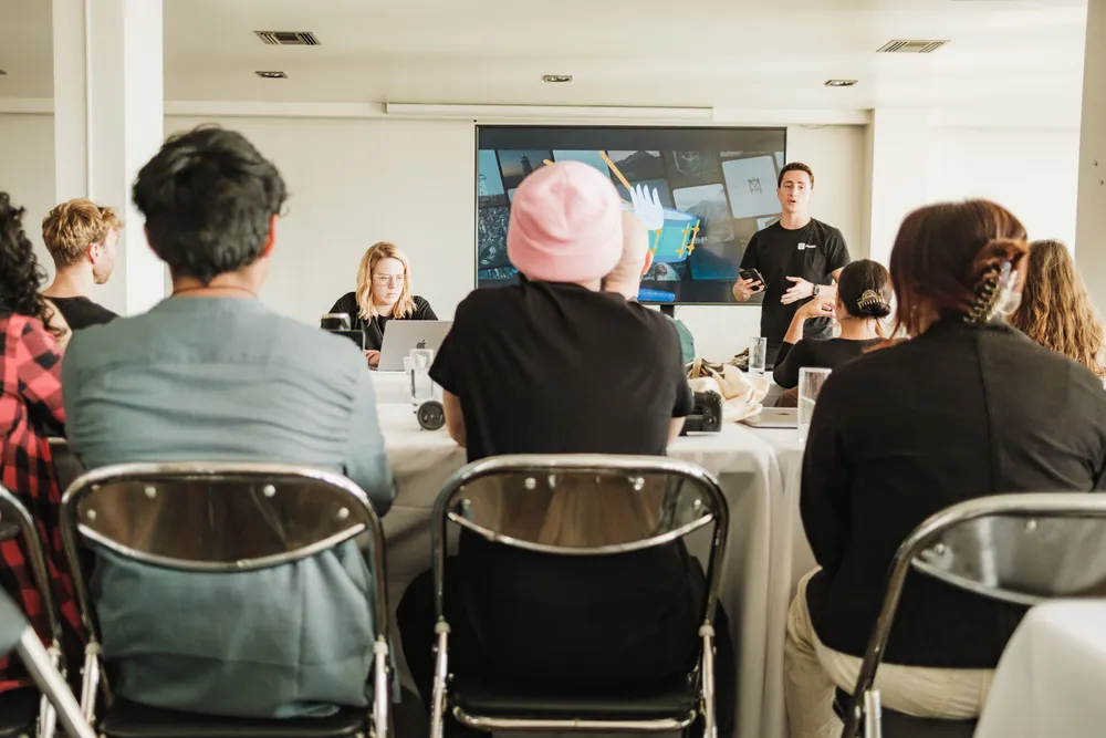 Apresentação em uma sala com participantes sentados.